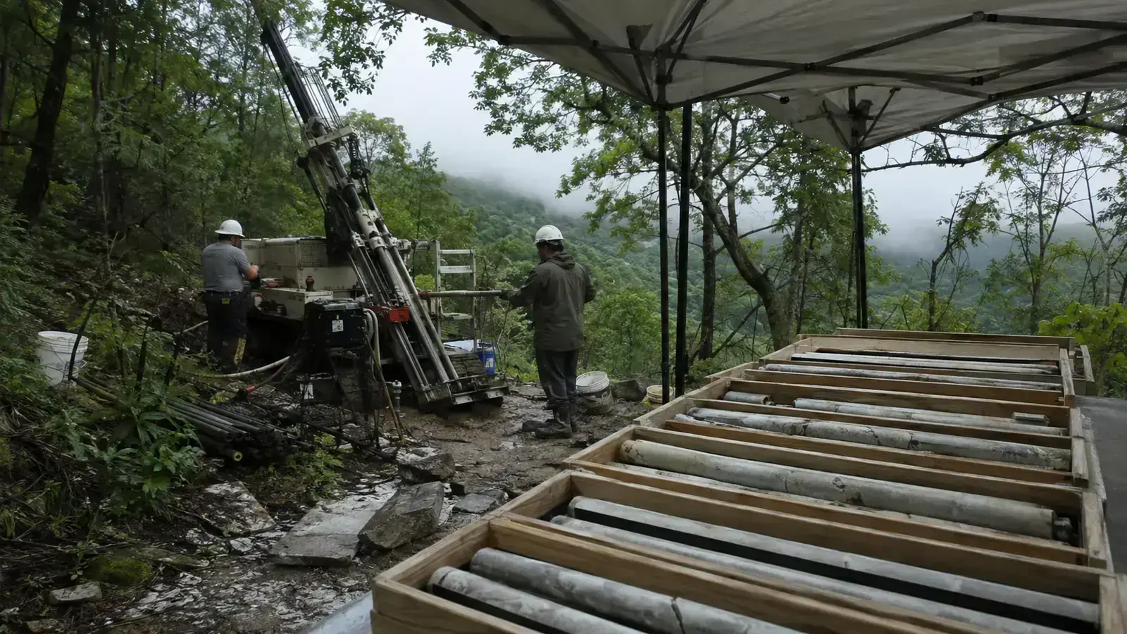 Diamond drill rig and core trays at a wooded Kentucky fluorspar exploration site